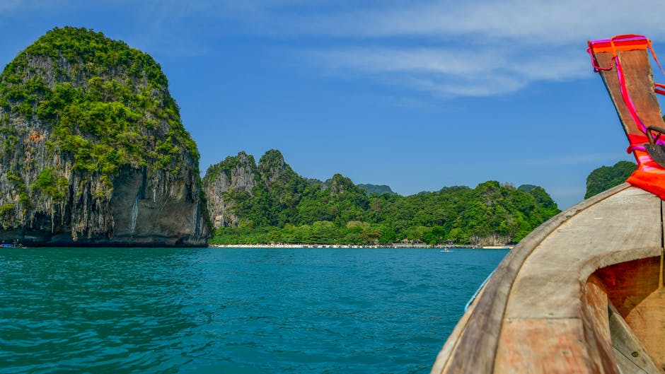 Explore the stunning limestone cliffs and turquoise waters of Krabi, Thailand, from a traditional longtail boat